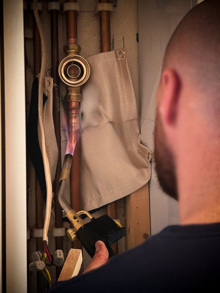 L&L Engineer working on central heating pipes