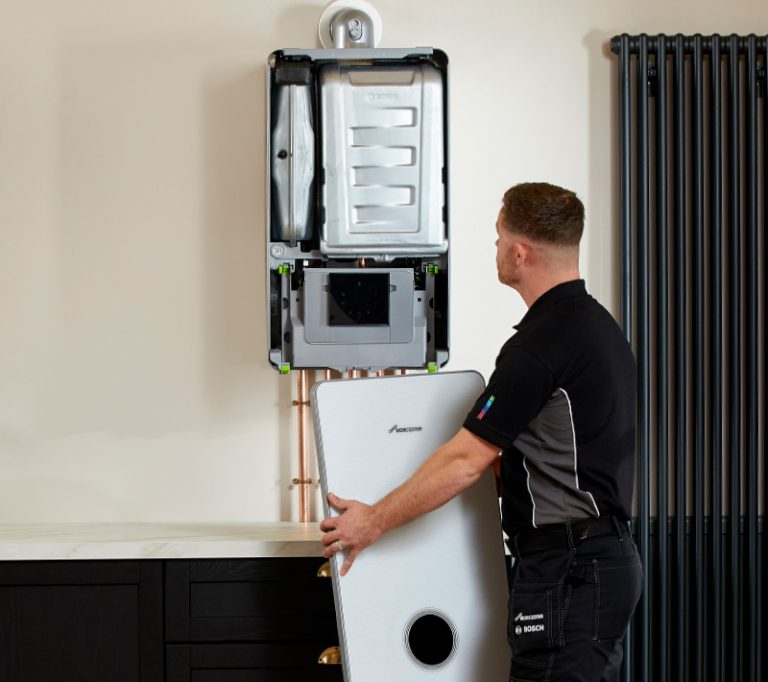 Combi boiler with engineer holding the cover showing the internals